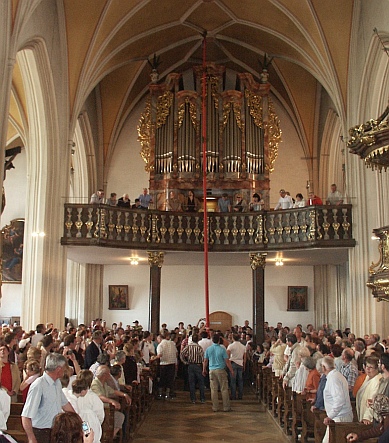 Die Kerze wird stehend in der Kirche zum Altar getragen